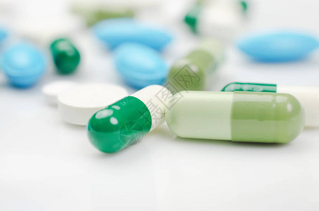 特写药房主题白色表面上的蓝色和绿色药丸图片
