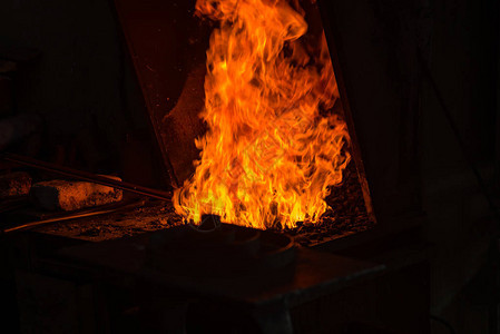铁匠用火花烟在铁匠铺里制造火焰图片
