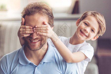 父亲和儿子在一起时笑着小男孩在遮着图片