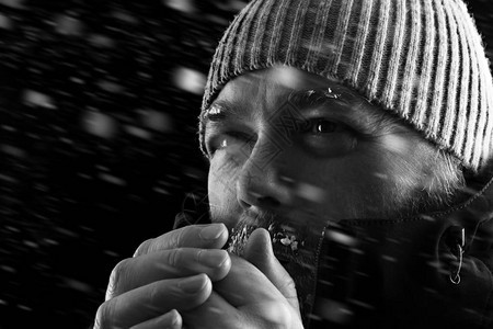 冰冷的人站在暴风雪中试图取暖背景图片