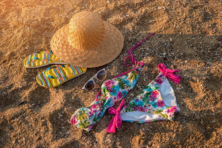 帽子和翻滚鞋沙子上多彩的泳衣穿着夏天的风格图片