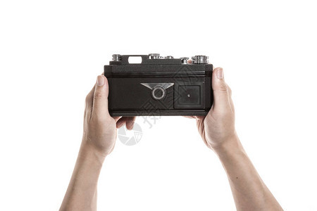一个男人手拿着一台古老的相机用来拍摄孤图片