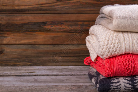 木制背景的暖织毛衣一套手工制作的拖车图片
