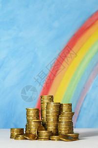 以蓝天和彩虹为背景的金澳元硬币图片