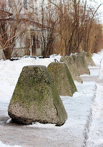 道路旁房屋附近的反恐金字塔形混凝土基座背景图片