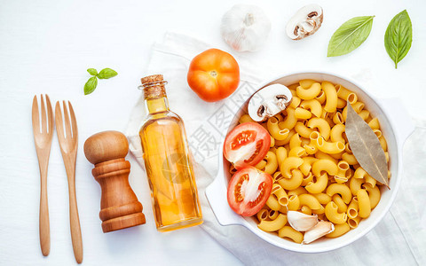 意大利食品概念和菜单设计意大利面肘通心粉与配料甜罗勒番茄大蒜特级初榨橄榄油欧芹月桂叶和香菇设置在图片