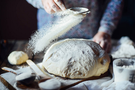 关闭了面包师揉面团的视图自制面包手在木桌上准备面包团准备传统的自制面包女人手揉新图片