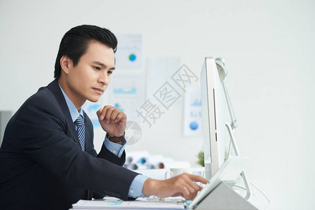亚洲企业家在其工作场所使用数字平板电脑图片