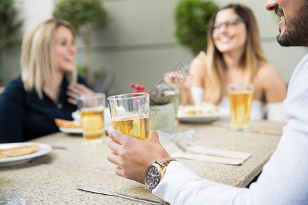 年轻人和一些朋友在一家餐馆喝啤酒图片