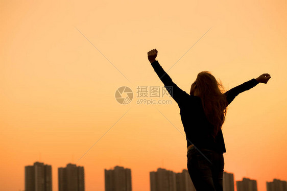 成功女子手举起日落天图片