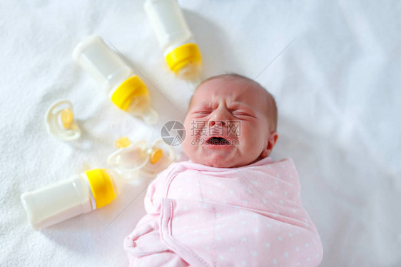 带着奶瓶哭泣的新生女婴儿配方奶粉新出生的孩子图片