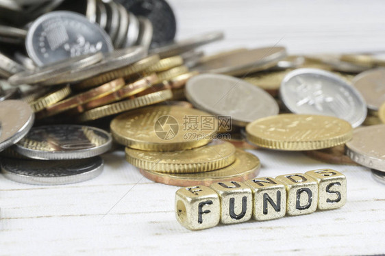 用字词FundS和硬币在木制背景上的骰子筹资和商业概念图片
