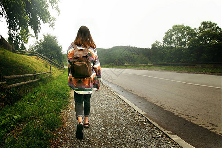 带着背包走在山上路的女旅行者旅行概图片