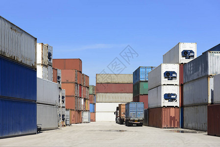 船厂的集装箱堆垛和等待出口国际的蓝天卡车图片