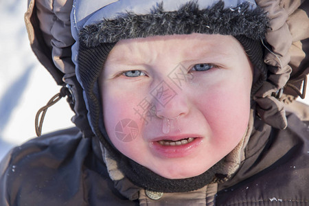 年幼儿童泪哭泣的肖像和冬衣雪中图片