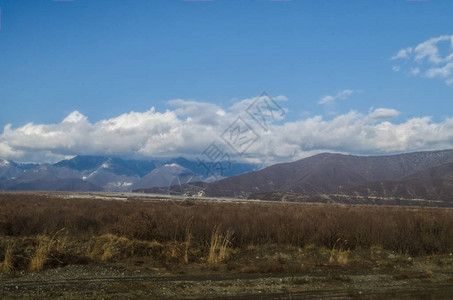 冬季的雪覆盖了山地多云的莫纳廷和田地阿塞拜疆高加索GakhShekiZa图片