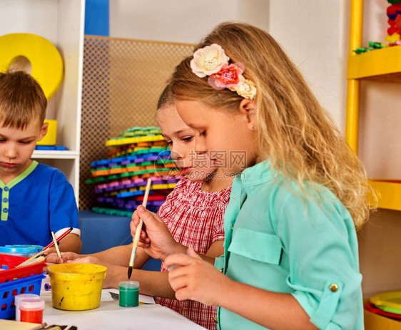 小学生在艺术学校课上画孩子在桌子上用颜料画幼儿园里的男孩和女孩绘画教育培养孩图片