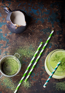 绿茶奶茶GreenMatchaLatte装饰了火柴粉茶和纸草背景