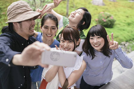 一群在公园集体拍照的日本朋友旅游者图片素材