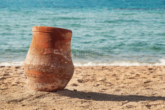 老陶罐站在海边的沙滩上图片