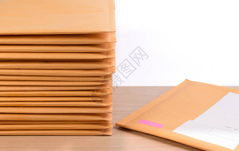 在木制桌子上堆放着白色背景颜色的泡沫包装加邮袋信封包装防冲图片