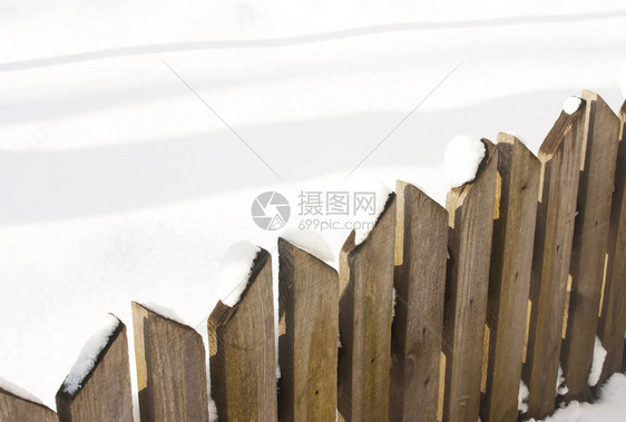 木栅栏特写与雪图片