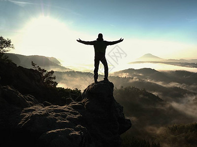快乐的男人在露天悬崖上举起的手势胜利图片