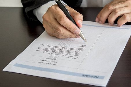 特写商人或求职者在简历表上签名高清图片