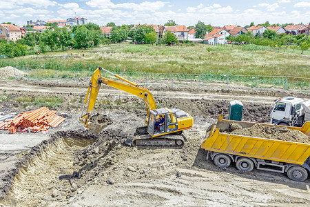 大挖土机正在挖掘一个坑图片