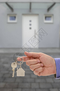 门前房地产经纪人手中的房子钥匙图片