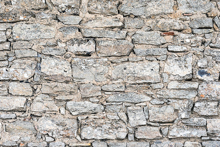 从天然石材制成的粗糙墙壁的背景图片