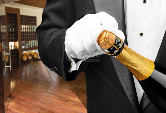 一个服务员打开了一瓶香槟和酒窖在背景图片