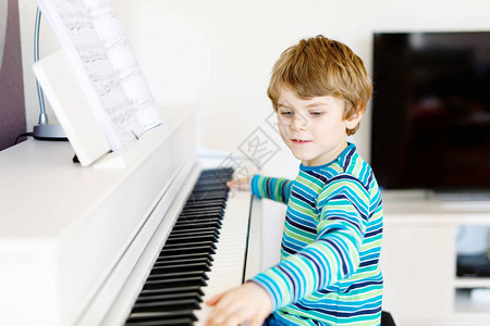 漂亮的小男孩在或音乐学校弹钢琴学龄前儿童学习演奏乐器很开心教图片