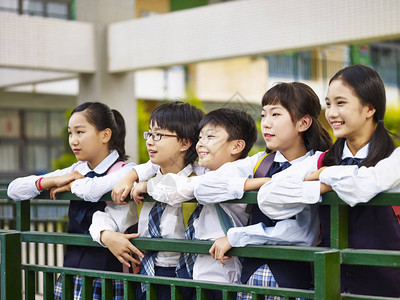 教学楼一群穿着制服的快乐和微笑的小学生的肖像背景