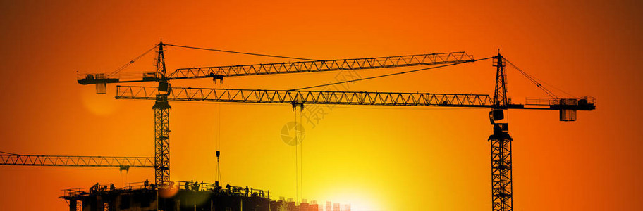 工业建筑起重机和在日出时与工人图片