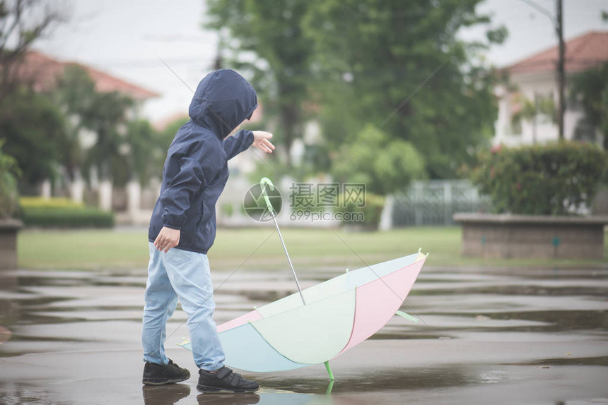 雨后在公园玩耍时拿着多彩的伞子欢乐快图片