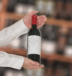 高级天主教女酒管员向葡萄酒店或酿酒厂的顾客提供一瓶白牌红酒图片