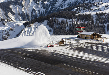 冬季高山边的吹风机扫雪者正在清理小型机场高空图片