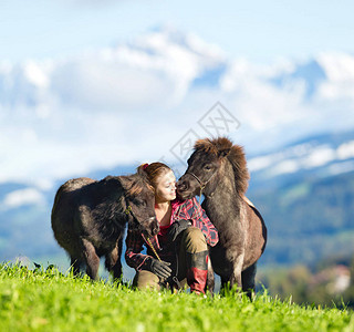 有两只迷你设得兰小马的年轻女子两匹马和美丽的女士户外图片