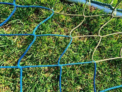 黄蓝横越足球网足球在目标网中野外操场上草地图片