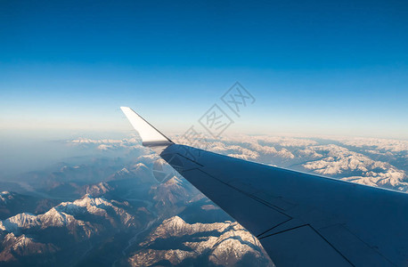 在飞行过程中透过窗户飞机看雪覆盖的意大利和奥斯特赖希阿尔卑斯背景图片