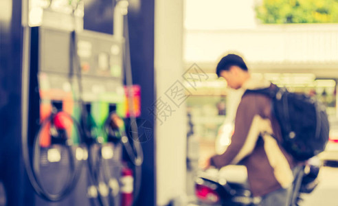 在加油站用自行车的人模糊图像白天是图片