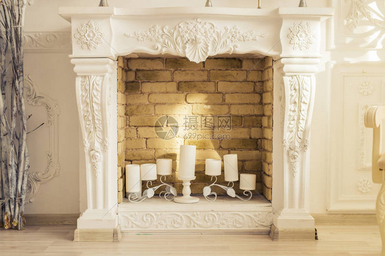房间里有蜡烛的白色装饰壁炉图片