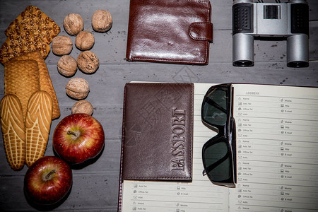 饼干胡桃苹果钱包望远镜护照墨镜和在桌图片