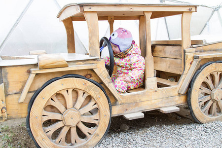 驾驶一辆木汽车的愉快的孩子图片