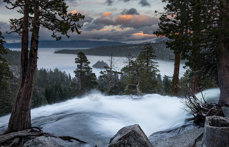 从下鹰瀑布顶端的Tahoe湖的Emerald湾日落是雪融化的水流从内华达图片