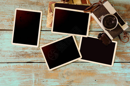 Retro相机和木制桌上空的旧即时纸相片册空白照图片