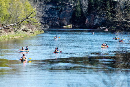 旅游者享受水上运动野河沿岸的皮划艇图片