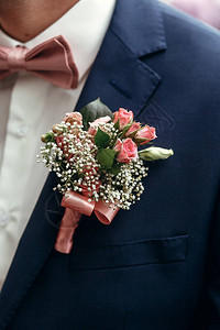 时尚的新郎或新郎穿着粉红玫瑰布丁和弓领带装扮早上准备参图片