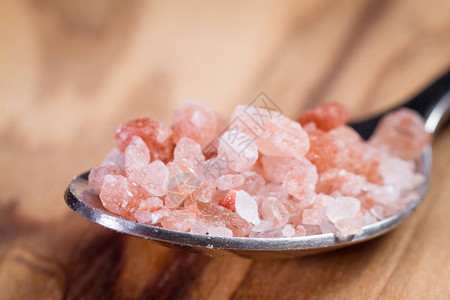 一勺子上的喜马拉雅粉红盐水晶和图片